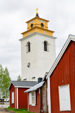 View of Gammelstad Church Town with its iconic white bell tower and traditional red wooden cottages in Gammelstaden, Norrbotten County, Sweden.