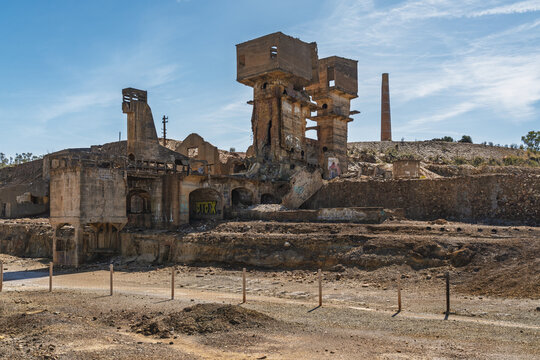 View of the abandoned industrial structures and brick chimney of the historic Minas de Sao Domingos mine site in Corte do Pinto, Beja District, Portugal.