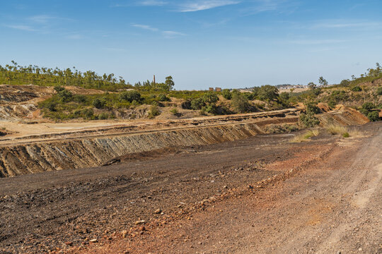View of the historic Minas de Sao Domingos mining landscape with rugged terrain, exposed earth, and sparse vegetation in Corte do Pinto, Beja District, Portugal.