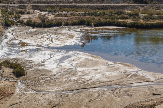 View of the historic Minas de Sao Domingos mining site featuring sediment patterns and water in Corte do Pinto, Beja District, Portugal.