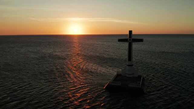 Catholic cross in sunken cemetery in the sea at sunset, aerial view. Sunset at Sunken Cemetery Camiguin Island Philippines.