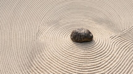 Naklejka premium Smooth Rock on Calm Sand with Spiral Patterns Creating Tranquil Scene
