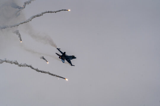 View of an F-16C Fighting Falcon of the Turkish Air Force performing a flare release maneuver during the Antidotum Airshow in Leszno, Greater Poland Voivod, Poland.