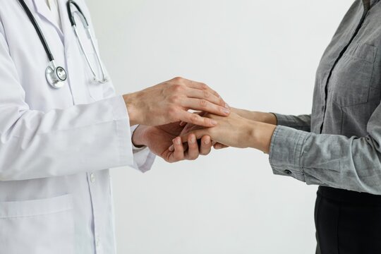 Doctor holding patients hands isolated on white background
