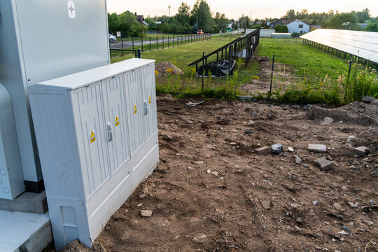 Dabrowa Gornicza, Silesian Voivodeship, Poland - 23 August 2026: View of electrical cabinets installed on a construction site near a solar power plant with green fields and trees in the background.