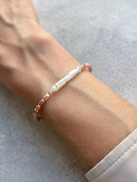 Elegant female hand wearing pearl bracelet in soft natural light - luxury jewelry fashion detail with timeless beauty aesthetic