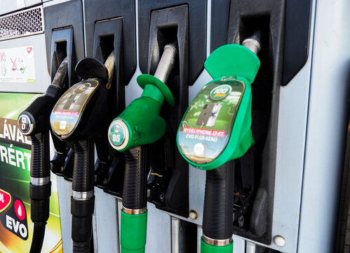 Close-up of fuel dispenser nozzles for diesel and unleaded gasoline at a MOL gas station.