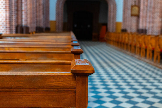 Wooden church pews and checkered tile floor inside historic Gothic church, architectural interior and religious heritage	