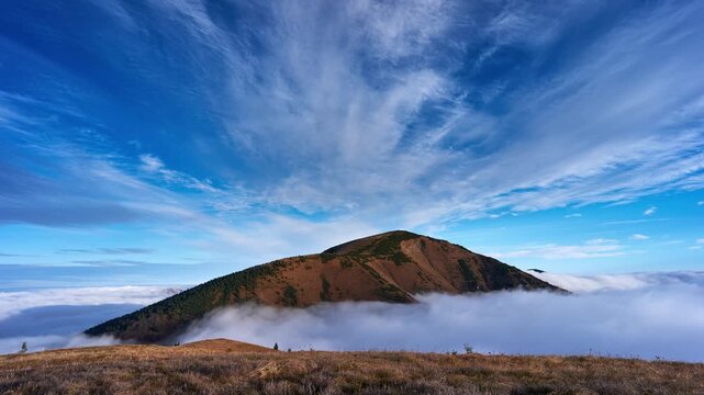 Mountain Peak Above Sea of Fog with Blue Sky and Cirrus Clouds Timelapse