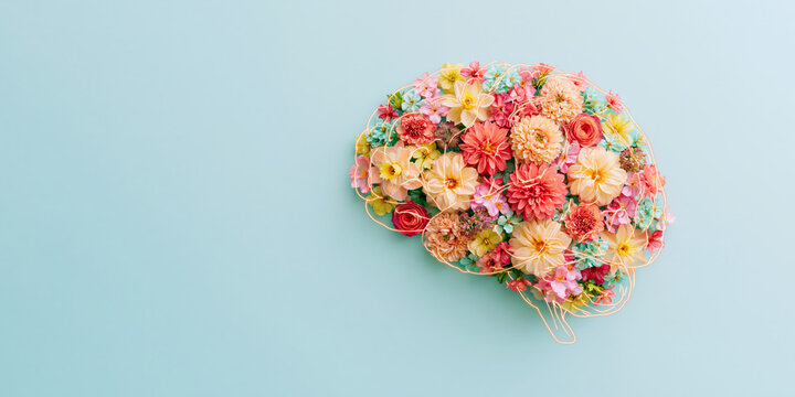 Colorful floral arrangement shaped like a human brain on a light blue background, symbolizing neurodiversity and mental health awareness