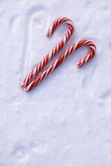 Naklejka premium Two red and white candy canes on white snow