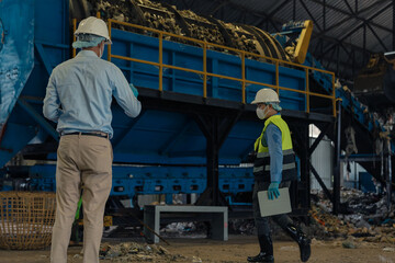 Fototapeta premium Engineers inspecting thermal waste treatment process inside waste management recycling factory.