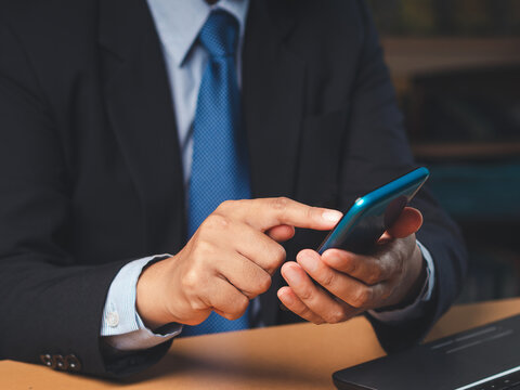 Person Using Smartphone While Wearing Formal Clothing