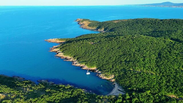 Wide aerial view of a secluded sandy beach with clear turquoise water, rocky shoreline and dense green vegetation along Bulgaria&rsquo;s southern Black Sea coast.