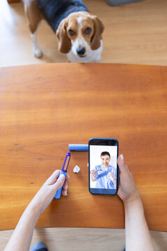 point of view of a woman holding a semaglutide injection pen while following a virtual doctor consultation on a smartphone 