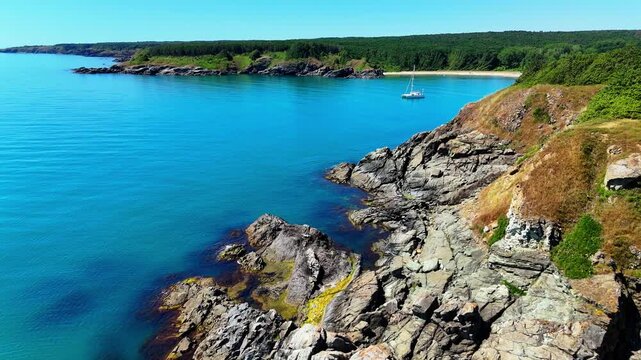 Wide aerial view of a secluded sandy beach with clear turquoise water, rocky shoreline and dense green vegetation along Bulgaria&rsquo;s southern Black Sea coast.