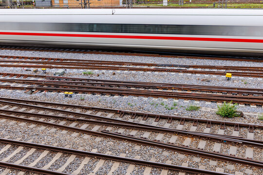 High angle view of motion blurred white high speed train passing over multiple railway tracks, rail transport and infrastructure concept