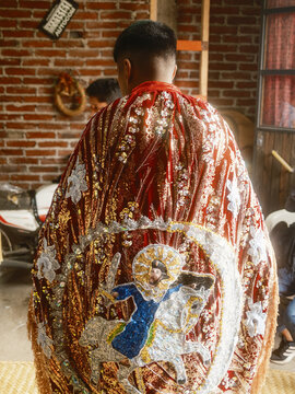 Angahuan, Michoacan, Mexico - 24 July 2026: View of a participant in the traditional Moros y Cristianos dance wearing an ornate red and gold cape with an embroidered horseman.