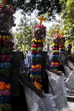 Uruapan, Michoacan, Mexico - 20 April 2025: View of Aguadoras Uruapan participants in traditional dress carrying decorated water vessels on their heads during a cultural procession.