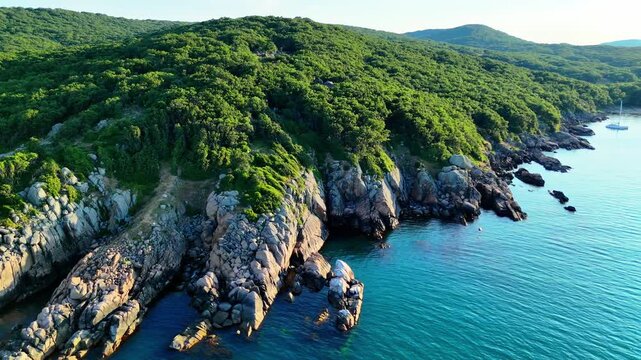 Wide aerial view of a secluded sandy beach with clear turquoise water, rocky shoreline and dense green vegetation along Bulgaria&rsquo;s southern Black Sea coast.