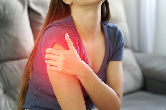 Close up of hand covering deltoid muscle showing post vaccine shoulder injection pain