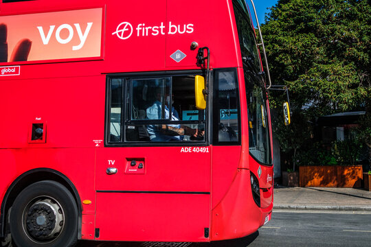 Close-Up Of The Front Of A Red First bus Doouble-decker Bus, Showing The Driver At The Wheel