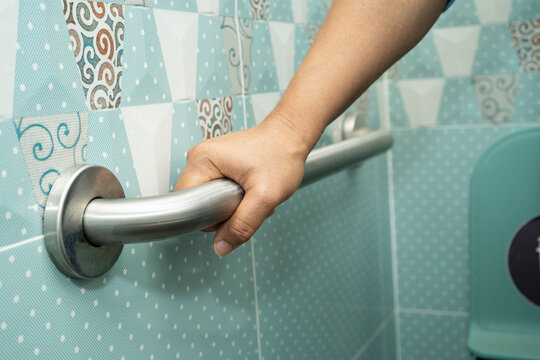 Asian elderly woman patient use toilet bathroom handle security in nursing hospital, healthy strong medical.