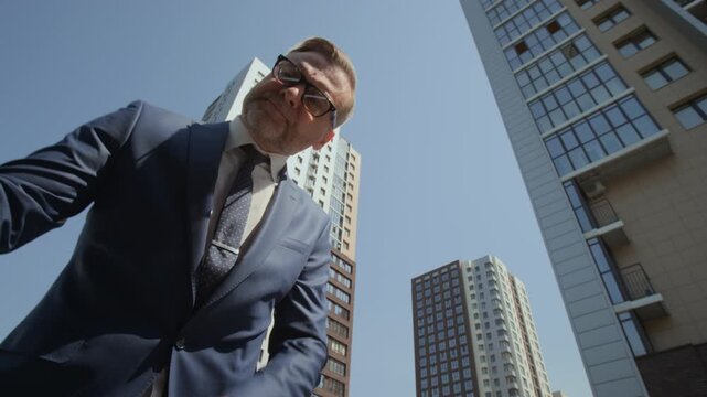 POV of middle aged Caucasian businessman opening car trunk, putting briefcase inside, waving hand to close it, low angle shot. Perfect for smart vehicle and modern transport commercials