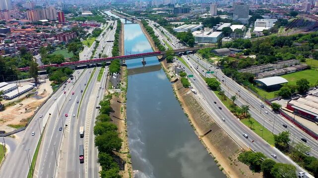 S&Atilde;O PAULO, BRASIL - 15 de AGOSTO de 2026: Vista a&eacute;rea de trem metropolitano da CPTM cruzando ponte sobre o Rio Tiet&ecirc; e pistas da Marginal Tiet&ecirc;