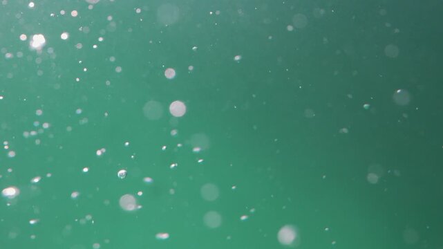 Abstract close-up of turquoise water bubbles and light