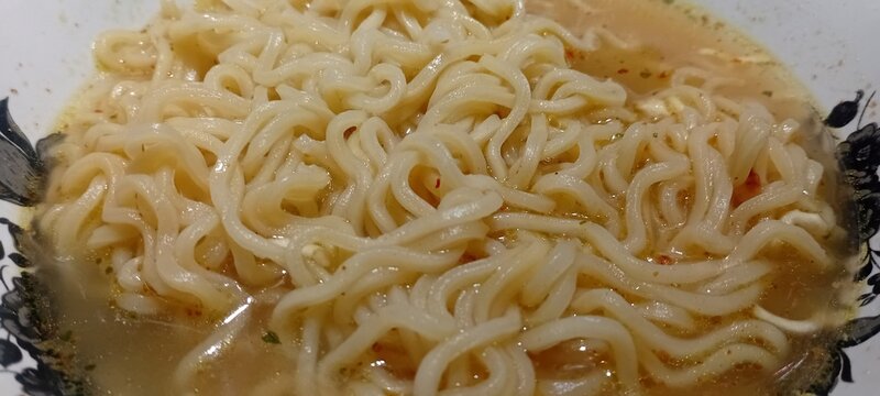 Close-up of steaming instant ramen noodles in a savory broth
