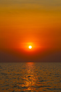 Kampong Phluk, Siem Reap Province, Cambodia - 05 February 2020: View of the sun setting over the calm waters of Tonle Sap, casting a warm golden glow across the surface.