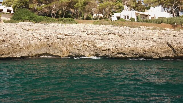 Boat cruise along the Mallorca coastline, passing a rocky headland
