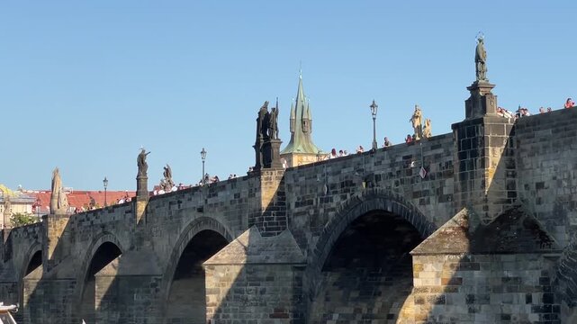panoramic view of historic stone arch bridge featuring repeating semicircular arches, triangular cutwaters, and sculpted statues on pedestals along upper deck with