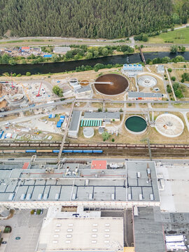 Aerial view of the Mondi SCP factory featuring large industrial sedimentation tanks, processing buildings, and railway tracks running alongside the facility in Ruzomberok, Zilinsky kraj, Slovakia.
