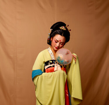 Elegant East Asian Woman in Traditional Yellow Hanfu Studio Portrait