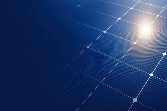 Close-up of solar panels reflecting sunlight under a clear blue sky, showcasing clean and renewable energy technology.