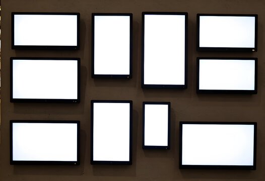 Digital signage and blank screens for advertising, multiple empty white displays on a textured wall for copy space
