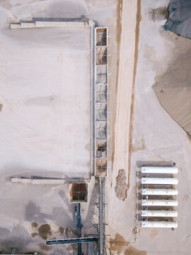 Aerial view of a concrete production facility featuring storage bins and a row of white liquefied petroleum gas tanks in an industrial site in Latvia.