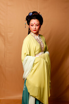 Elegant East Asian Woman in Traditional Yellow Hanfu Studio Portrait
