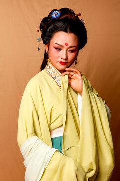 Elegant East Asian Woman in Traditional Yellow Hanfu Studio Portrait