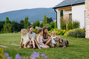 Fototapeta na wymiar Parents and daughters enjoying late summer together outside family home.