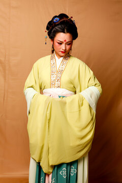 Elegant East Asian Woman in Traditional Yellow Hanfu Studio Portrait