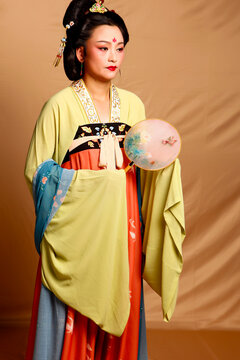 Elegant East Asian Woman in Traditional Yellow Hanfu Studio Portrait