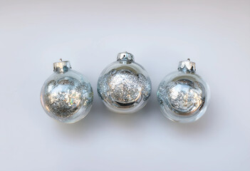 Obraz premium Christmas and new year celebration concept, three silver glitter ornaments on a festive white background