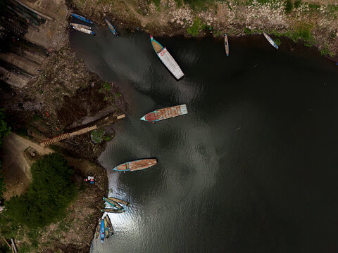 Aerial view of traditional boats moored along the riverbank at Dusun Dempok in Sengguruh, Malang, East Java, Indonesia.