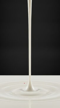 Smooth Pouring Stream of Fresh Milk creating Ripple Effect on Dark Background