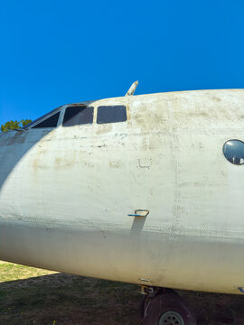 Old airplane fuselage on display at an outdoor location under a clear blue sky during daylight hours
