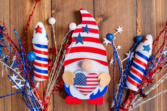 Patriotic gnome holding an American flag, wearing a festive hat.