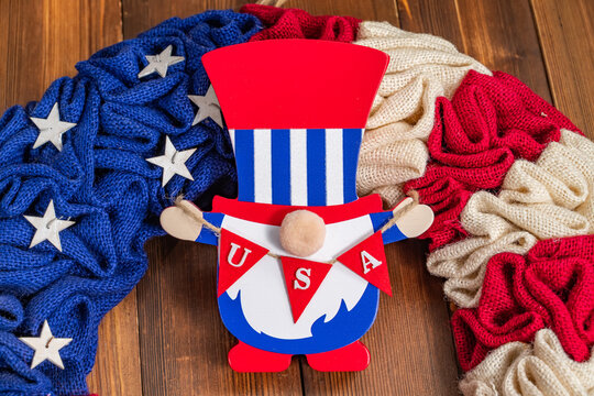 Patriotic gnome holding an American flag, wearing a festive hat.